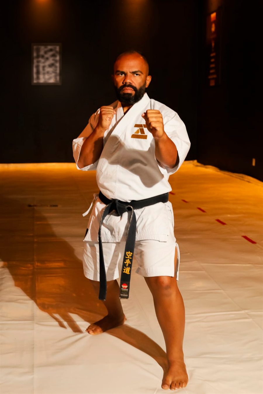 Sensei Mário César Brito da Costa em posição de guarda, de karategi branco e faixa preta